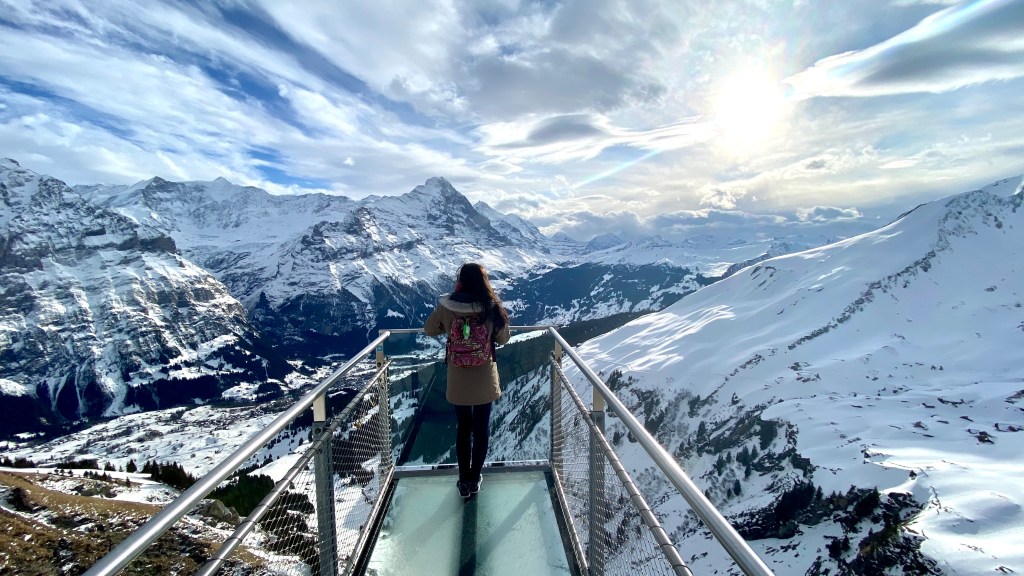 Standing at the edge of a walkway starring out into snowy mountain range