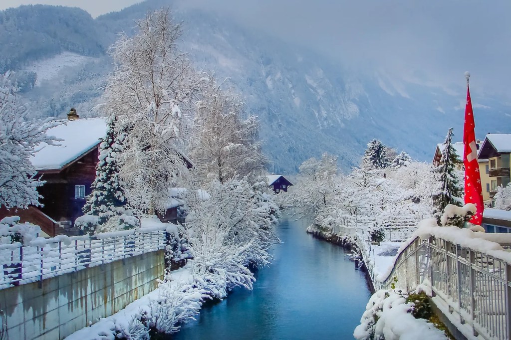 Snowy mountain range with river running along its town.